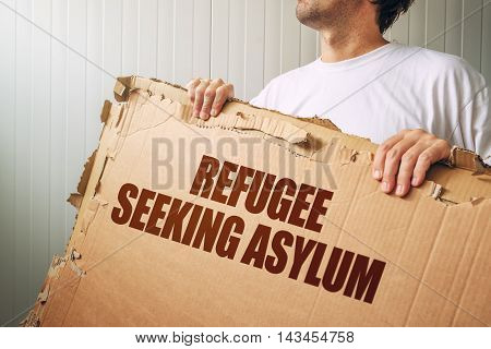 Refugee seeking asylum in foreign country male immigrant with cardboard banner