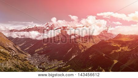 Snow capped alpine mountains and valley with Zermatt town. Trek near Matterhorn mount.