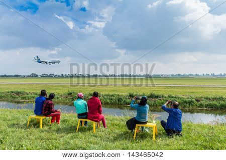 Polderbaan Vijfhuizen the Netherlands - August 20 2016: family of plane spotters watching passenger jet land