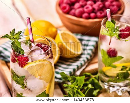 Alcohol cocktail. Wooden boards glasses with ice cubes alcohol cocktail. Cocktail two hundred ninety four cocktail raspberry mojito with lime and mint leaf. Country outdoor. Top view on wooden boards.