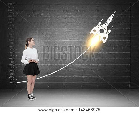 Woman witnessing skyrocket growth on blackboard. Concept of great business planning strategy and success