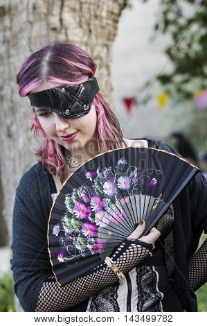 CAGLIARI, ITALY - May 29, 2016: Sunday at La Grande Jatte VIII Ed. At the Public Gardens - Sardinia - portrait of a beautiful young girl with fan and steampunk costumes