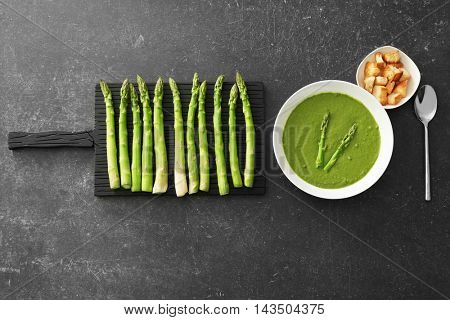 Tasty asparagus soup on table