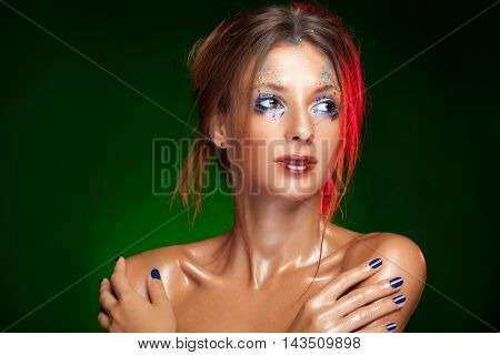 Girl with powder creative make up on green background in studio photo. Beauty and on stage make up