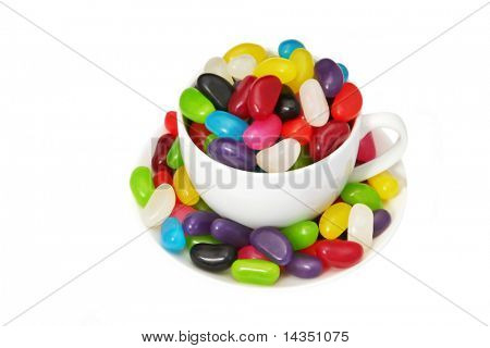 ถ้วยกาแฟเต็มไปด้วยสีสัน jellybeans แยกต่างหากบนเป็นสีขาว  พอที่จะตอบสนองใด ๆ หวานฟัน