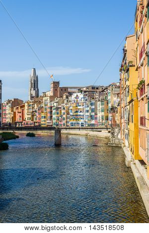 Onyar river crossing the downtown of Girona with bell tower of Basilica of Sant Feliu in background. Gerona Costa Brava Catalonia Spain.