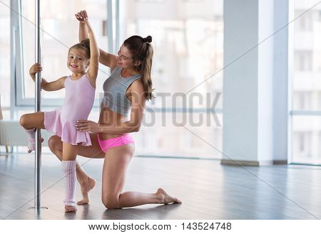 Adorable girl dancer and her teacher in the ballet studio