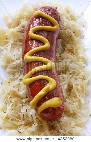 Bratwurst pølse på surkål med kommen frø og sennep.