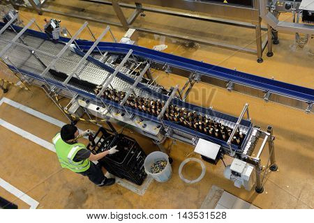 ST. PETERSBURG, RUSSIA - AUGUST 11, 2016: Worker at beer conveyor in the Heineken brewery. It was the first Heineken brewery in Russia, and now it can produce over 5 millions HL of beer per year