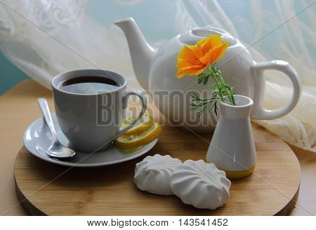 marshmallows and tea with flower on a wooden tray