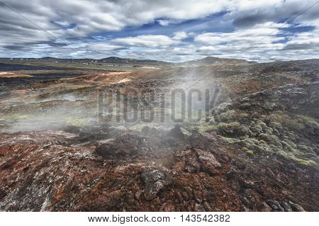 Inhospitable dramatic volcanic landscape full of steam at Krafla geothermal area, Iceland