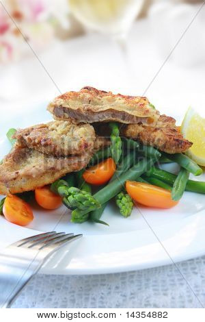 Schnitzel Weiner กับผักและมะเขือเทศสีส้มเล็กน้อย