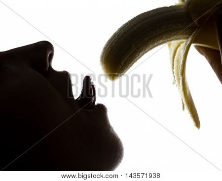 Young amazed woman in lacy lingerie holding a banana, she is going to eat a banana. she sucks a banana.