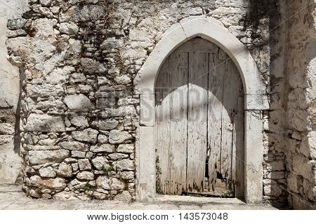 Old door in the stone walls of the village houses. Excellent background