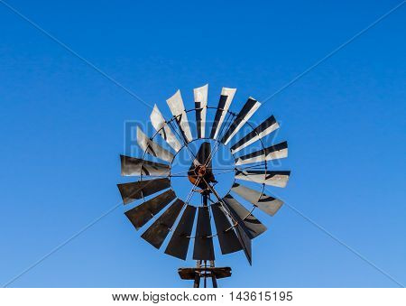 Photo of multibladed old windpump head against blue sky