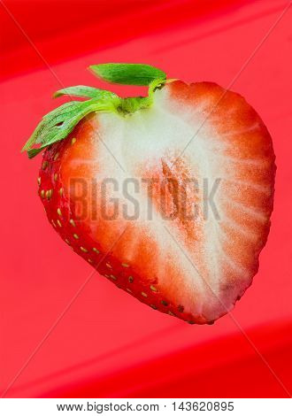 Cleaved single strawberry isolated on red background and clipping path