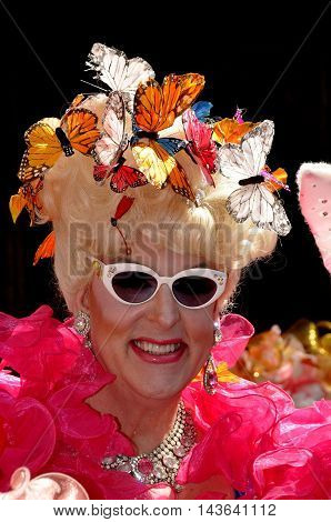 New York City - April 20 2014: Duchess Doris Dear sporting shades a frilly wrap and a butterly bonnet at the Easter Parade on Fifth Avenue