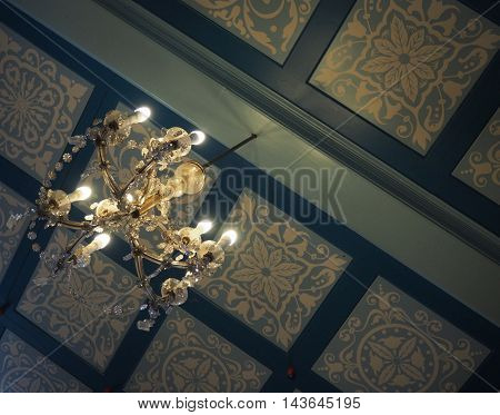 Rento Vintage Chandelier Against Blue Pattern Ceiling