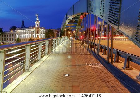Iron arched Mindaugas Bridge across Neris River in Vilnius with night lighting. Lithuania.