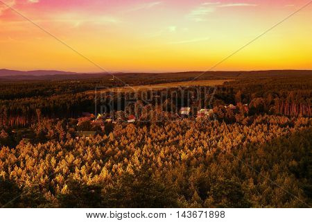 Sunset over the village Hradcany with airports in the background among the pine forests in the tourist area Machuv kraj in czech landscape