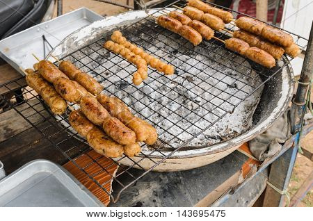 Display for sell BBQ with fiery sausages on the grill