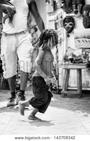 KARA, TOGO - MAR 9, 2013: Unidentified Togolese boy runs in the street. Children in Togo suffer of poverty due to the unstable econimic situation