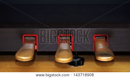 The pedal of the piano close up .
