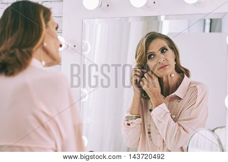 Mature woman getting ready in front of her vanity