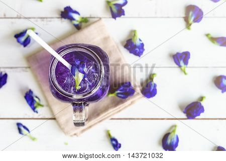 Glass of Butterfly pea or blue pea flower drink on white wooden table Top view