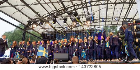 STOCKHOLM SWEDEN - AUG 21 2016: Happy swedish female soccer team waving swedish flags when the swedish olympic athletes are celebrated in Kungstradgarden Stockholm Sweden August 212016