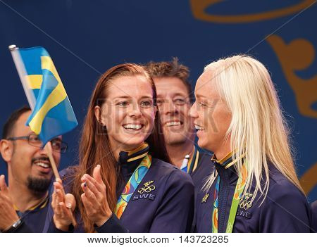 STOCKHOLM SWEDEN - AUG 21 2016: Swedish soccer player Lotta Schelin winning olympic silver waving the swedish flag when the swedish olympic athletes are celebrated in Kungstradgarden Stockholm Sweden August 21 2016