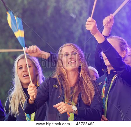 STOCKHOLM SWEDEN - AUG 21 2016: Happy swedish female soccer team waving swedish flags when the swedish olympic athletes are celebrated in Kungstradgarden StockholmSwedenAugust 212016