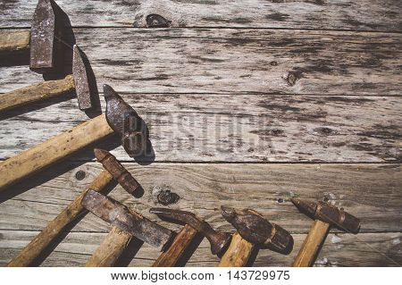 Set of old and rusty hammers on wooden background