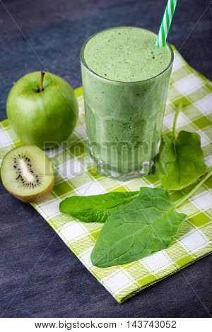green smoothie with spinach kiw iand apple on a dark background selective focus