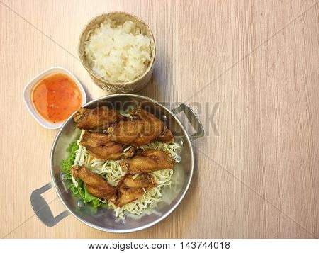 fried chicken and sticky rice on wooden table.