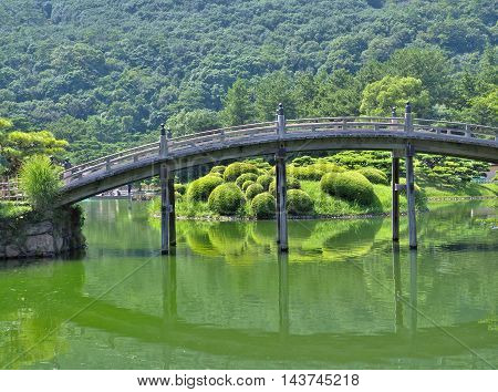 A wooden bridge - Engetsukyo in Ritsurin Garden in Takamatsu city, Kagawa Prefecture, Japan. Ritsurin Garden is one of the most famous historical gardens in Japan.