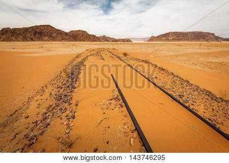 Sand dunes under dramatic sky with backfilled of sand railroad Wadi Rum Jordan. concept of global warming.