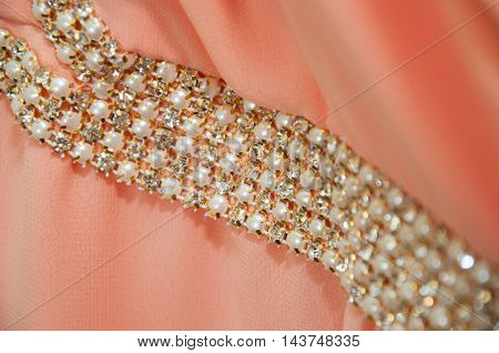 Shiny silver decoration on peach wedding dress