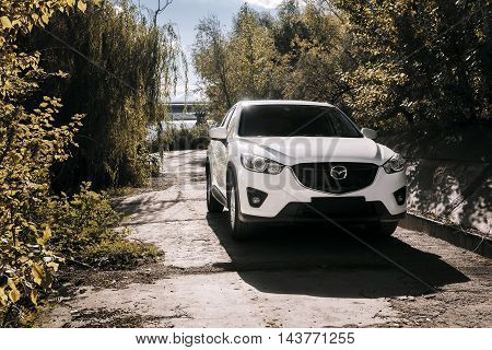 Saratov, Russia - August 30, 2014: Car Mazda CX-5 stand on asphalt countryside road near river at daytime