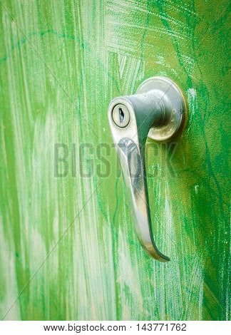 old rustic door handles or door knob against green metal plate background