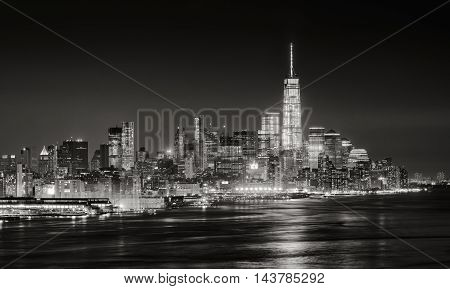 Skyscrapers of New York City Financial District illuminated at night. Aerial panoramic view of Lower Manhattan and the Hudson River in Black & White