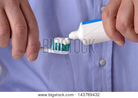 pouring toothpaste on toothbrush on white background.Toothpaste being squeezed onto toothbrush.