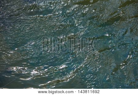 Reflections in the water with small waves. Abstraction texture background