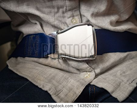 Passenger wearing seat belt in Airplane to save life while flying in sky. Safety and travel concept.