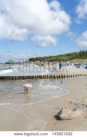 USTRONIE MORSKIE - AUGUST 15: Tourists enjoy the sunny weather and relaxing on the Baltic sea beach on 15 August 2016 in Ustronie Morskie, Poland.