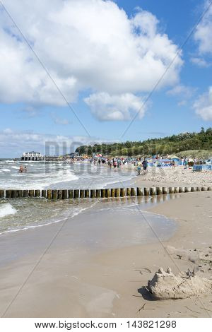 USTRONIE MORSKIE - AUGUST 15: Tourists enjoy the sunny weather and relaxing on the Baltic sea beach on 15 August 2016 in Ustronie Morskie, Poland.