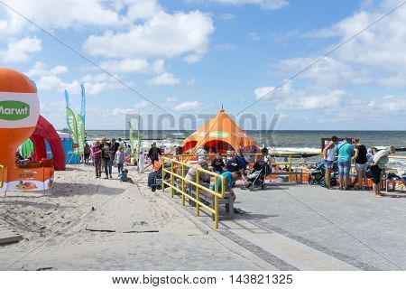USTRONIE MORSKIE - AUGUST 15: Tourists enjoy the sunny weather and relaxing on the Baltic sea beach on 15 August 2016 in Ustronie Morskie, Poland.