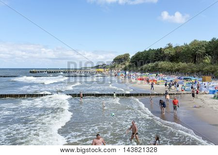 USTRONIE MORSKIE - AUGUST 15: Tourists enjoy the sunny weather and relaxing on the Baltic sea beach on 15 August 2016 in Ustronie Morskie, Poland.