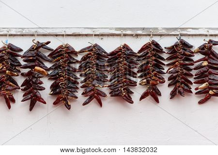 Strings of PDO Espelette chilli peppers drying, France