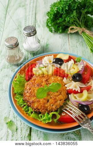 Breaded fried pork cutlet served with pasta salad. Rustic style